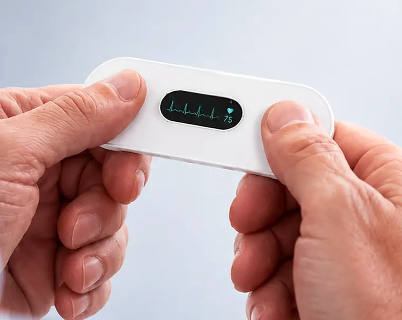 Hands holding the VitalWeave ECG recorder showing a heart rhythm